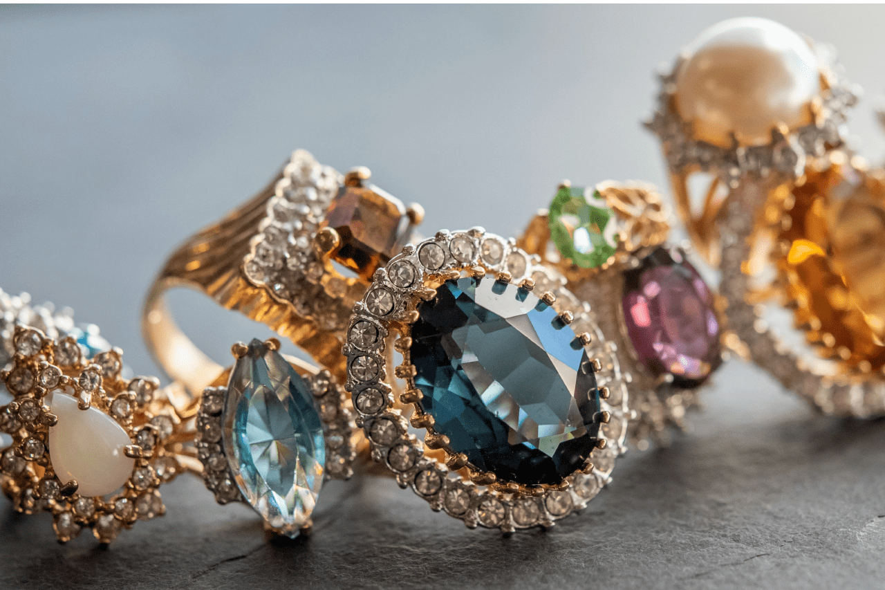 A number of ornate, gemstone rings of all different colors clustered together