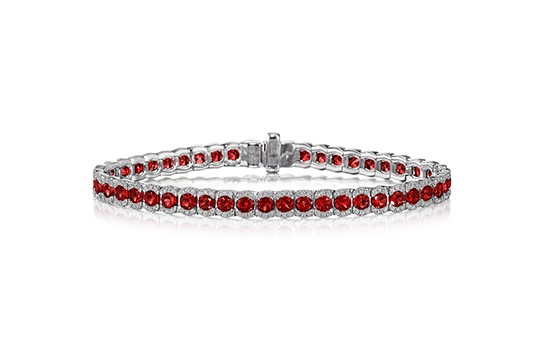 A silver line bracelet set with rubies against a white background