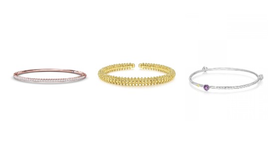 Three bracelets in a line, one a diamond and rose gold bangle, one a textured gold cuff, and one a silver bangle with a purple gemstone
