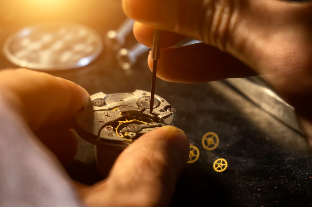 A watchmaker makes adjustments to the inner parts of a client’s watch to ensure it works perfectly