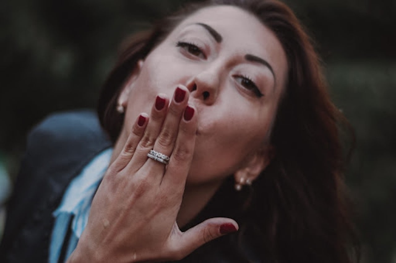 a lady blowing a kiss while wearing fashion rings