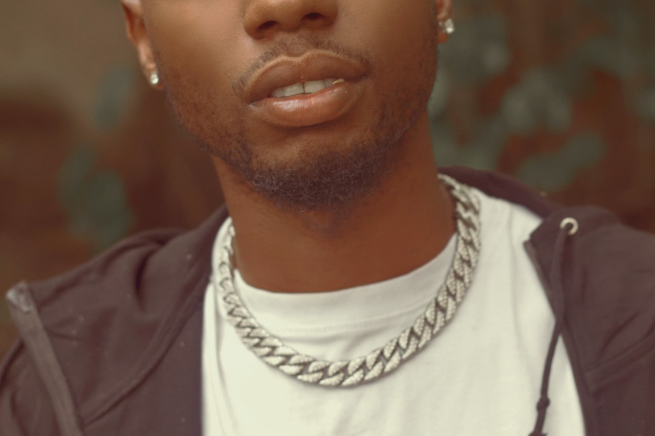 close-up image of a man wearing a bold silver chain necklace